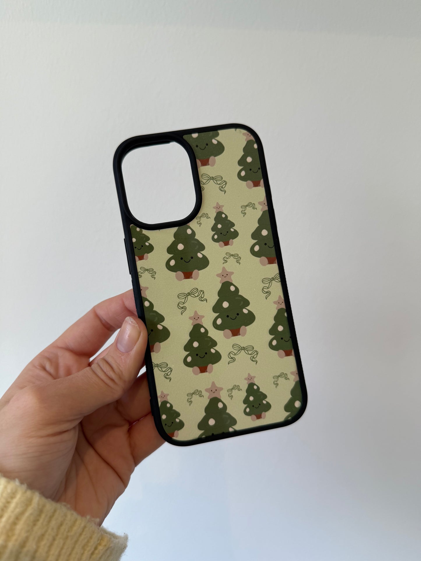 Christmas tree phone case. Green background. Cuddly toys.