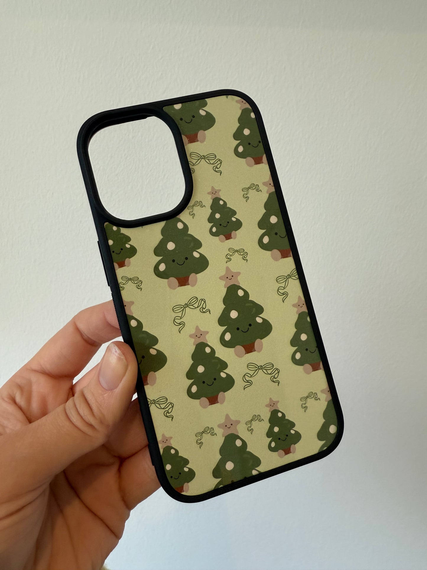 Christmas tree phone case. Green background. Cuddly toys.