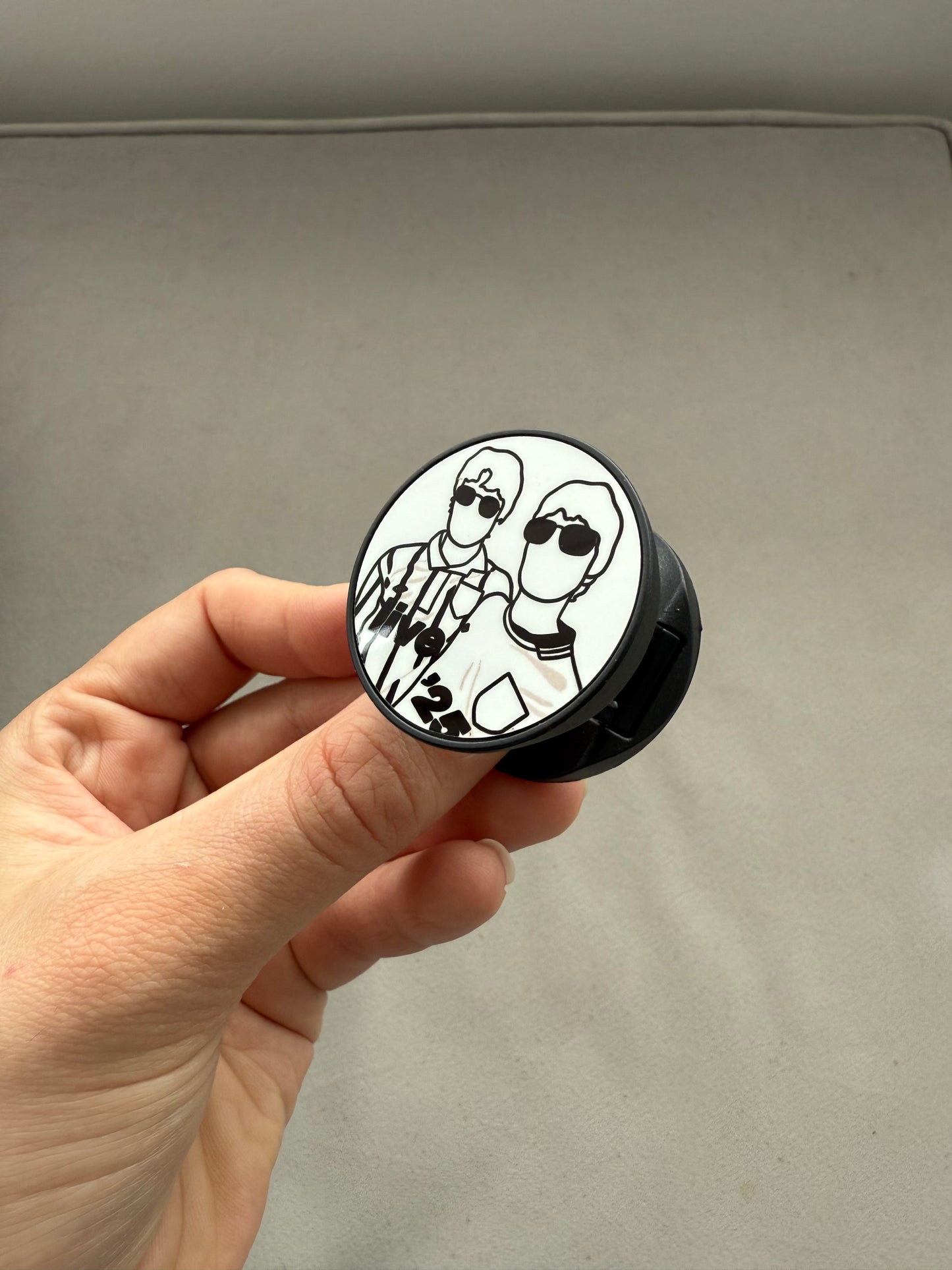 Live ‘25 phone pop socket. Liam and Noel